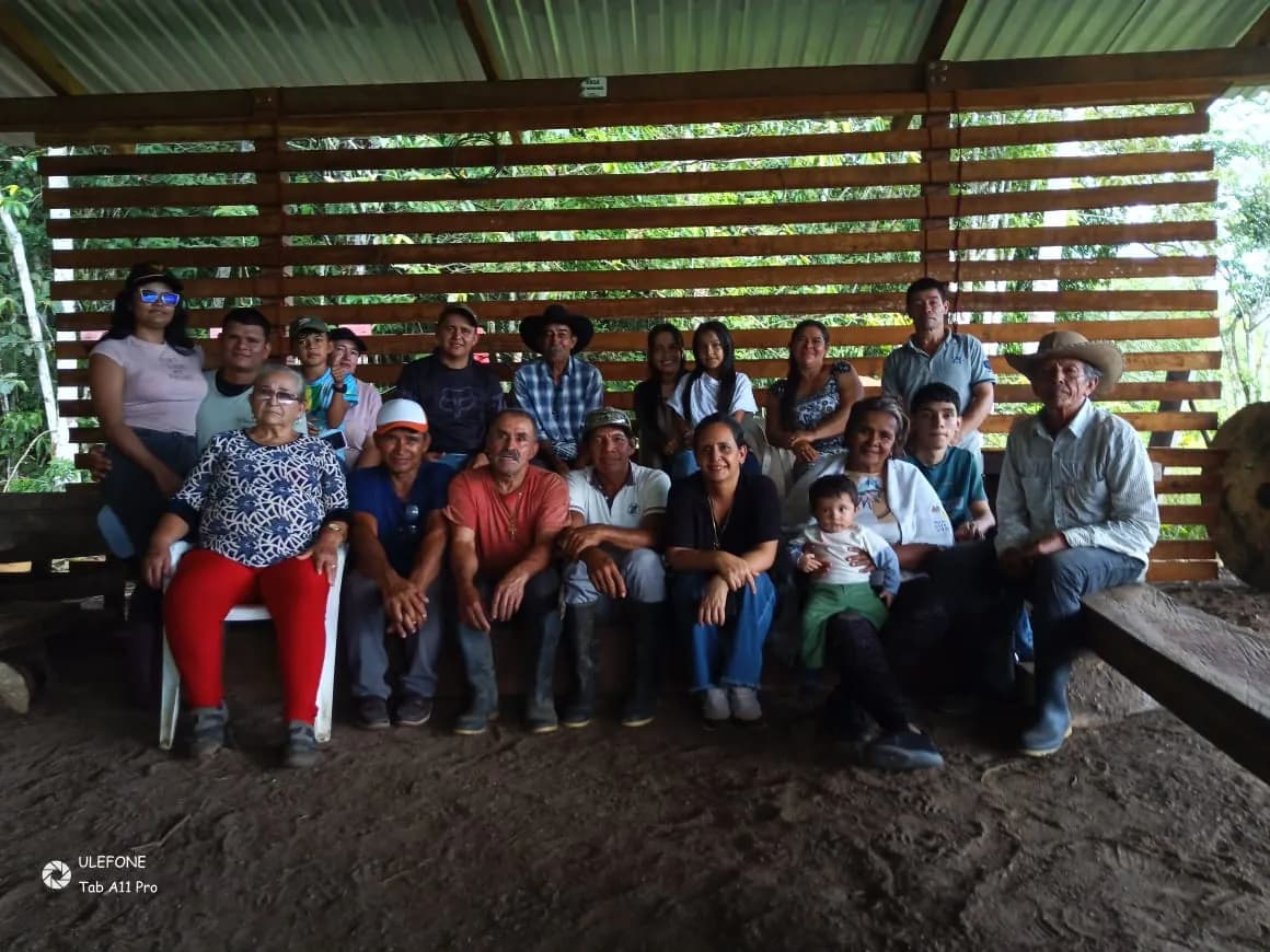 Socios de Coagroitilla reunidos bajo el cobertizo de acopio de madera
